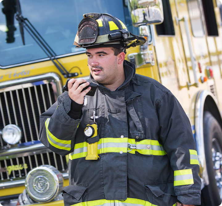 Firefighter using push-to-talk device in the field